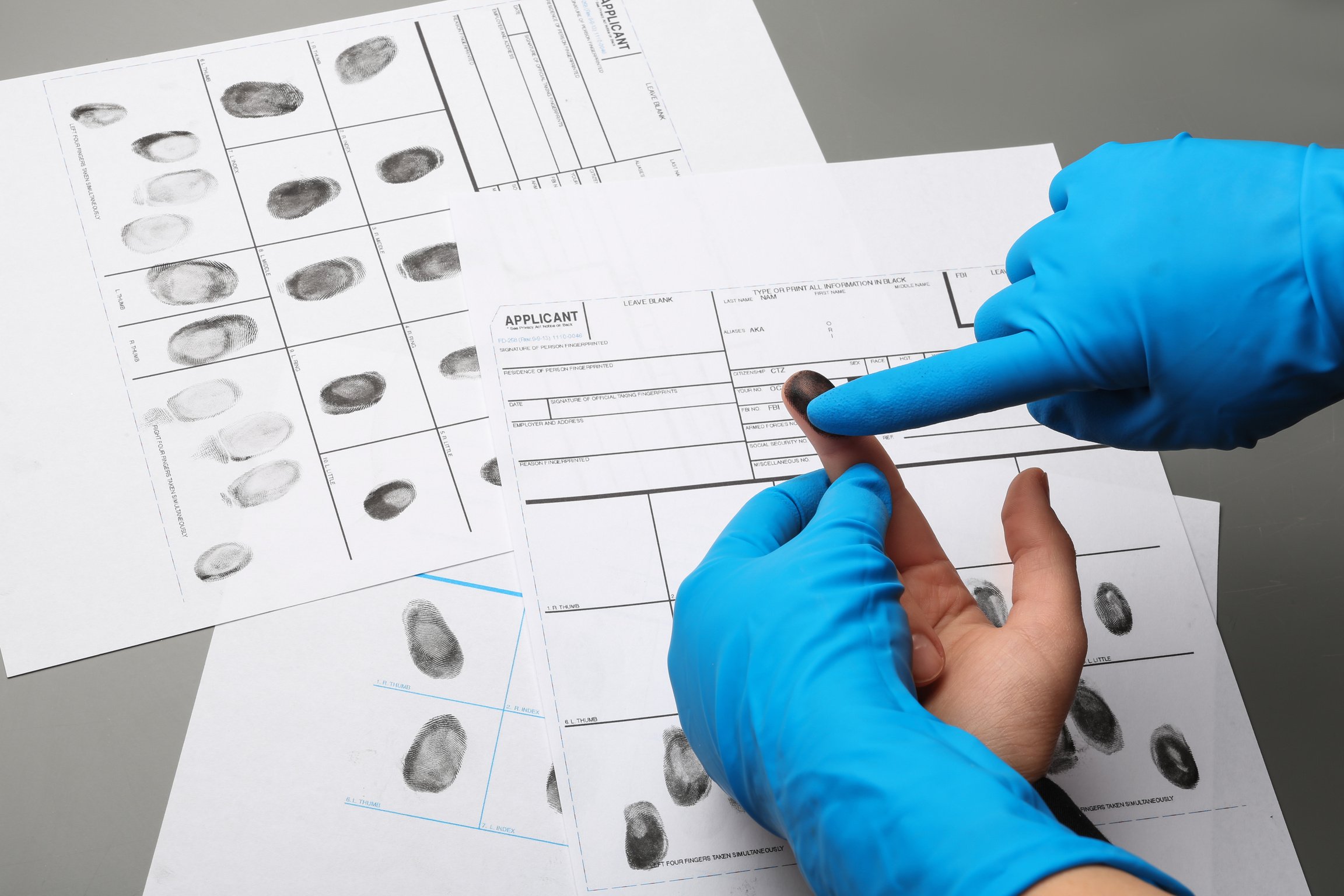 Investigator Taking Fingerprints of Suspect at Table, Closeup. Criminal Expertise